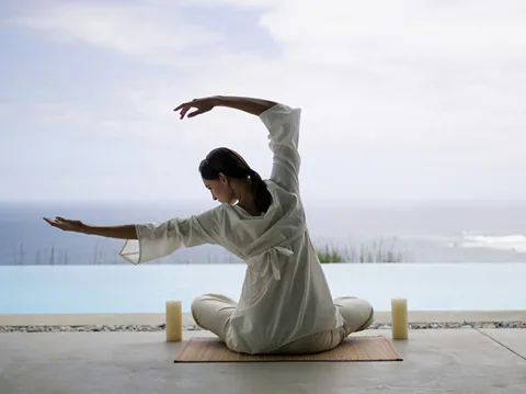 Illustrative photograph of a woman in white doing yoga