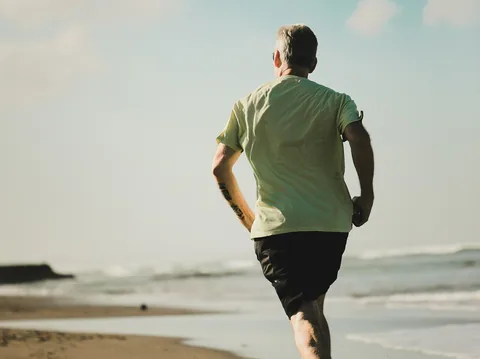 Illustrative photograph of an older man running on the beach