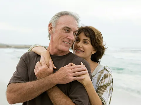 Illustrative photograph of a couple hugging on the beach